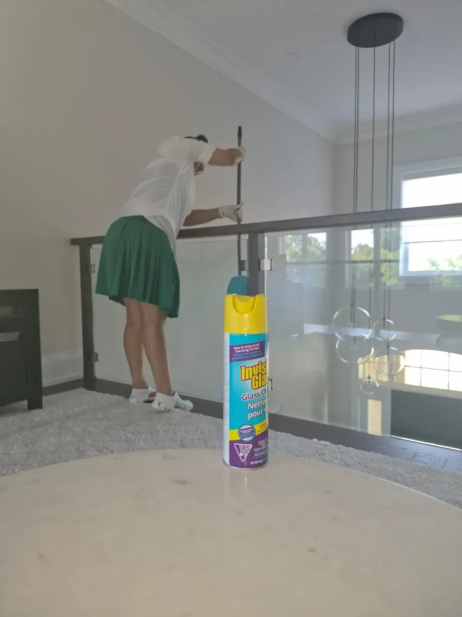 Fresh & Shiny cleaning an interior glass railing during recurring home maintenance in Ajax.