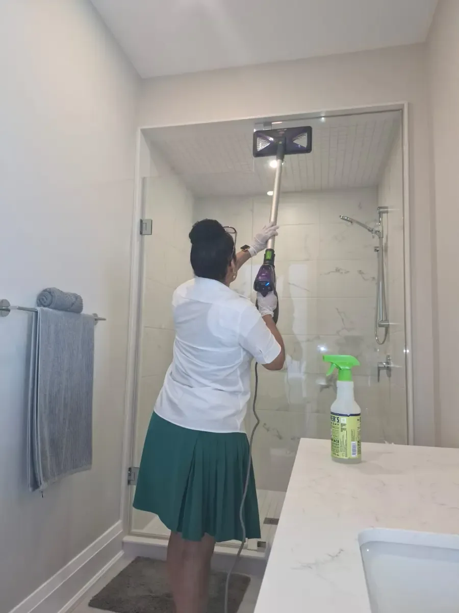 Fresh & Shiny using professional steam equipment for detailed shower-glass cleaning during a recurring Ajax home service.